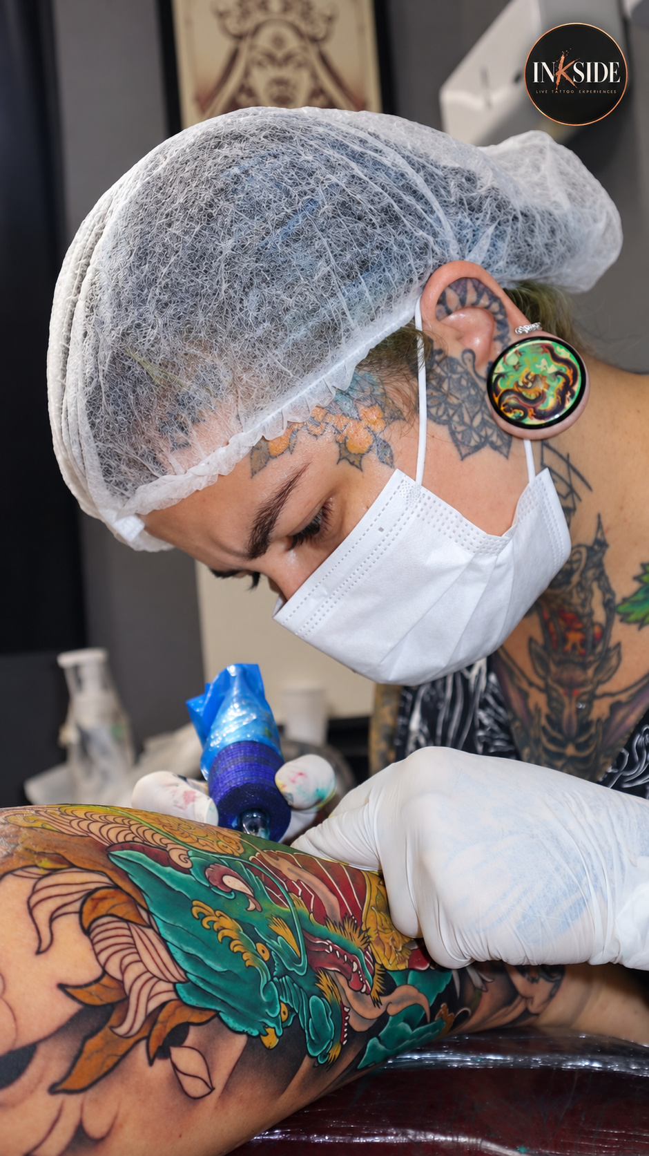Profissional com equipamentos de proteção realizando tatuagem